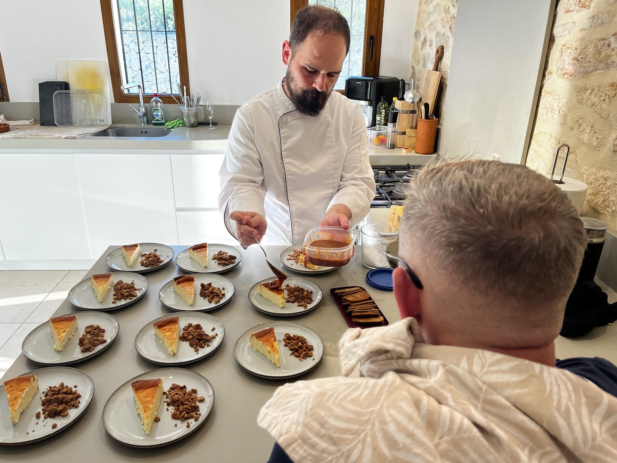 Chef preparing dessert with individual slices of Spanish cheesecake and crumble.